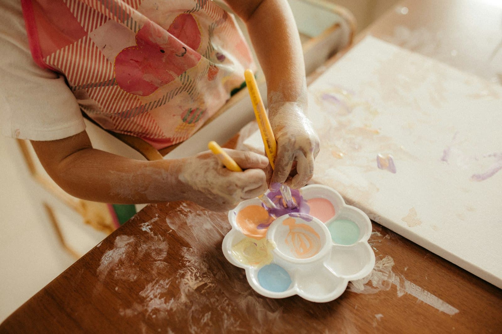 Niña haciendo deberes con material de estudio adaptado sobre la mesa